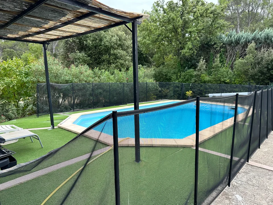 Het terras vóór de renovatie met hekwerk en kunstgras