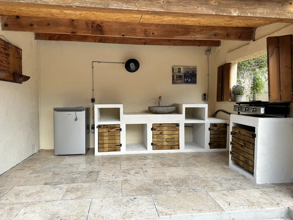 De overdekte zomerkeuken met houten balken