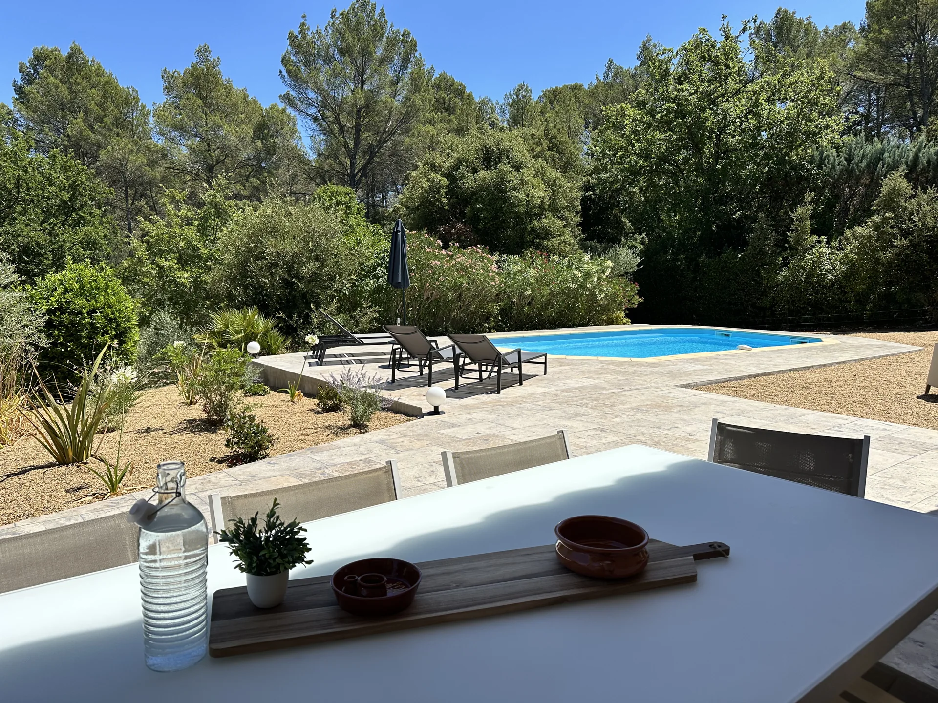 Het terras met eettafel, ligstoelen en privézwembad